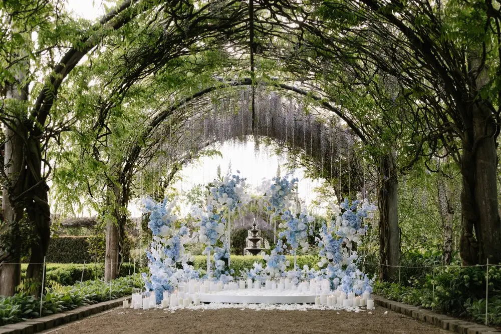 Alowyn Gardens proposal setup under the wisteria archway with blue and white florals